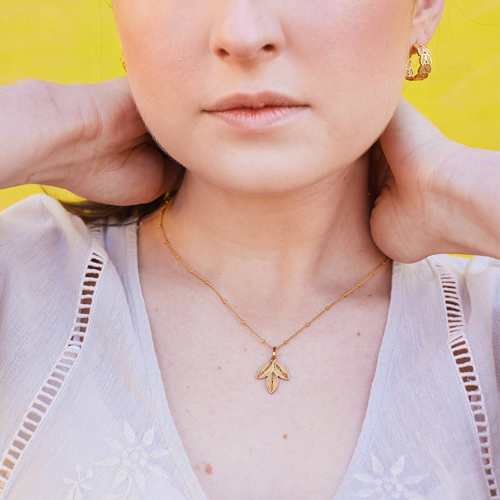 Model exhibiting the Laurel Hoops & Laurel Necklace in Gold