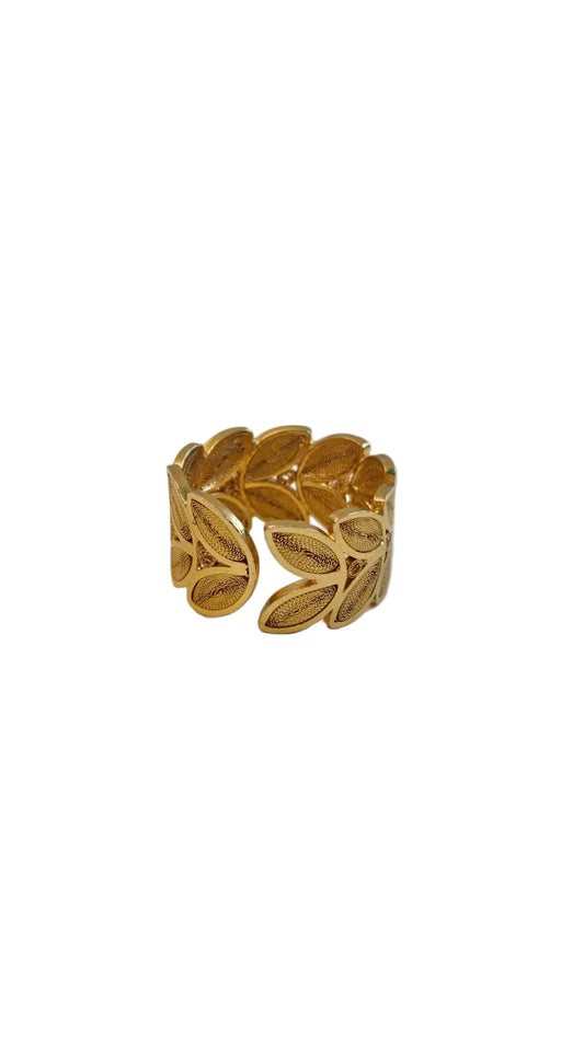 Gold leaf-patterned ring on a light gray background
